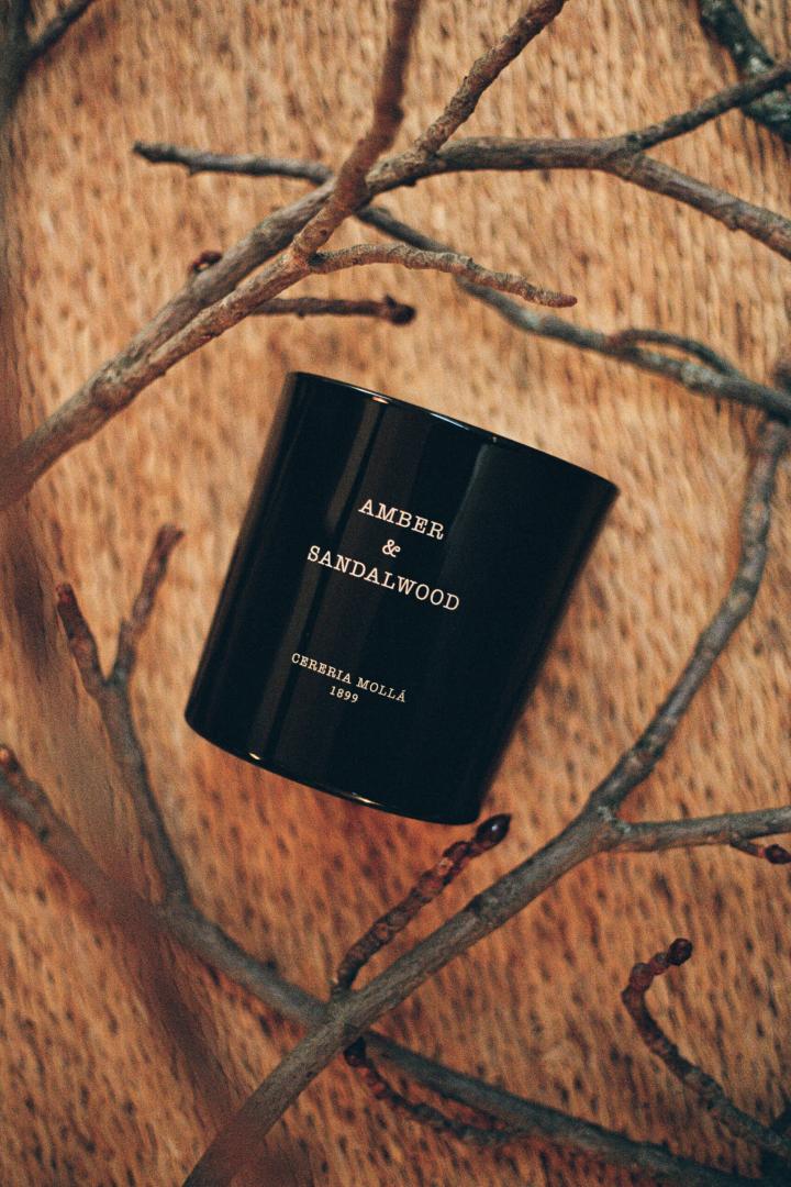 Brandende Amber & Sandalwood geurkaars op houten tafel