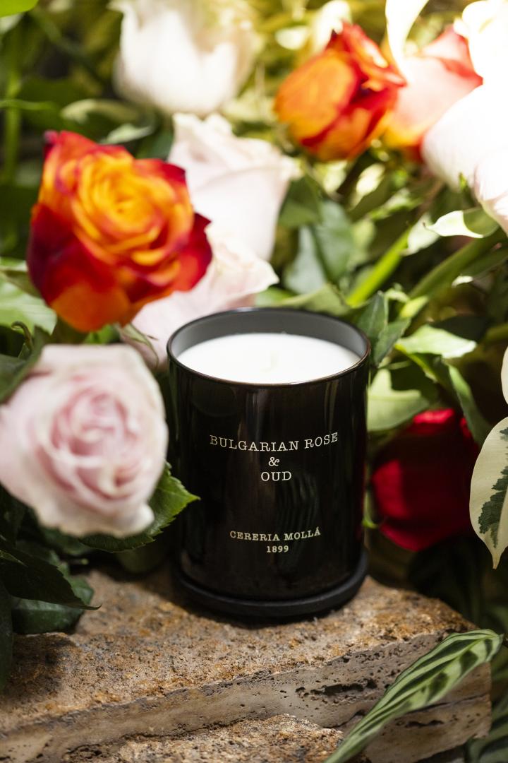 Bulgarian Rose & Oud 230g Geurkaars naast rozen – elegante en bloemige sfeer